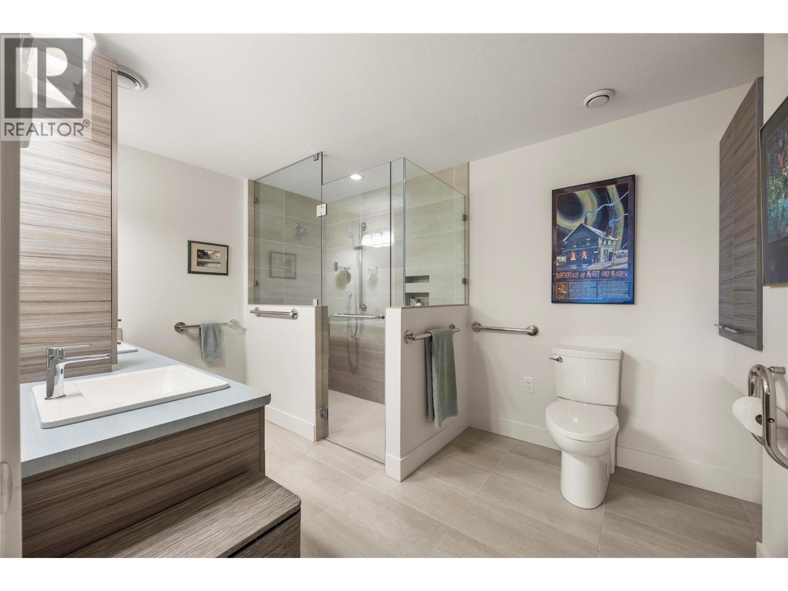 PRIMARY 4 PC ENSUITE: Elegant ensuite with dual sinks, curbless walk-in shower with custom tile surround and glass door, plus heated tile flooring - 2442 Bella Vista Street, Kelowna, BC