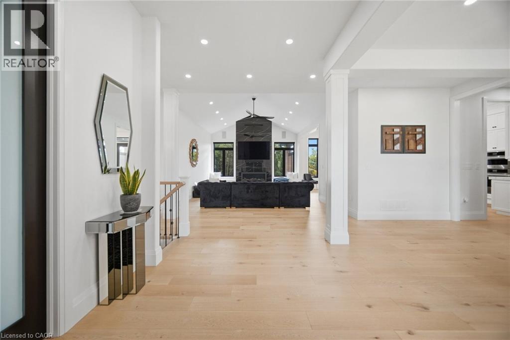 Hardwood flooring extending throughout, vaulted ceilings, recessed lighting, and a modern fireplace with a dark stone surround - 56 Augustus Street, Scotland, ON
