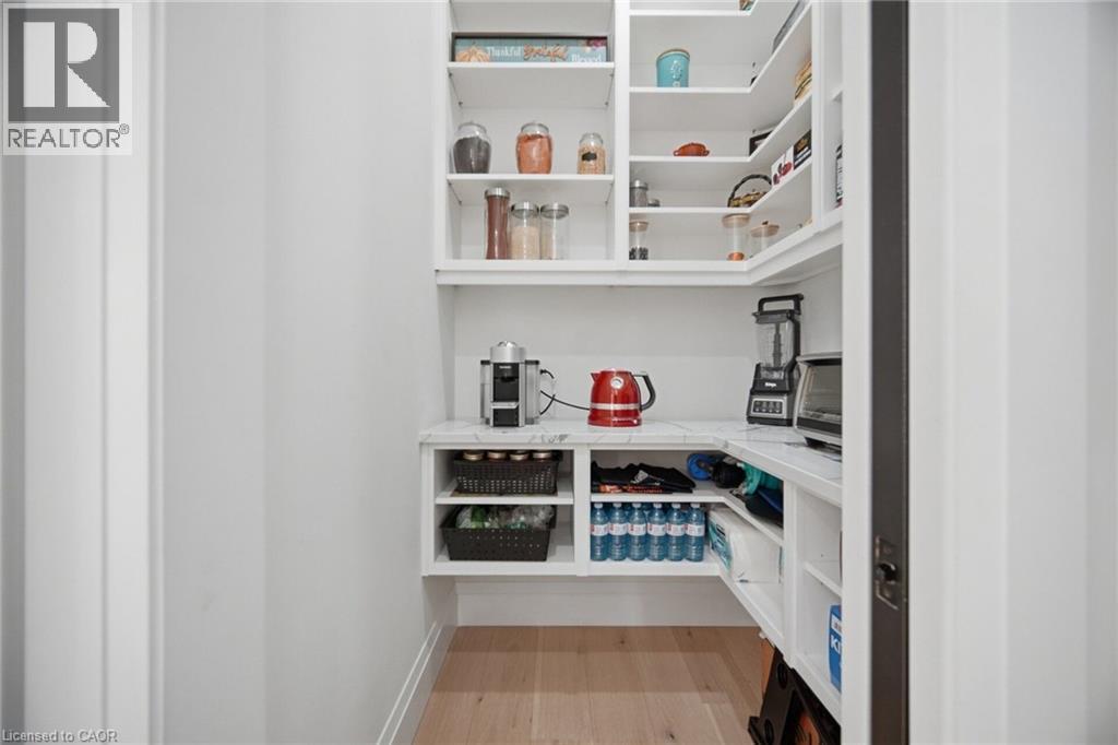 Built-in shelving with a marble-finish countertop, white cabinetry, and wood-finish flooring - 56 Augustus Street, Scotland, ON