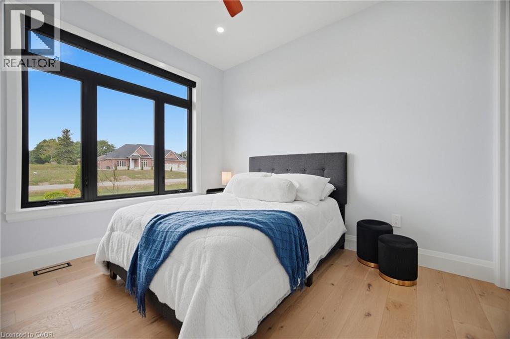 Expansive window with black frames, wood-finish flooring, white walls, and recessed lighting - 56 Augustus Street, Scotland, ON