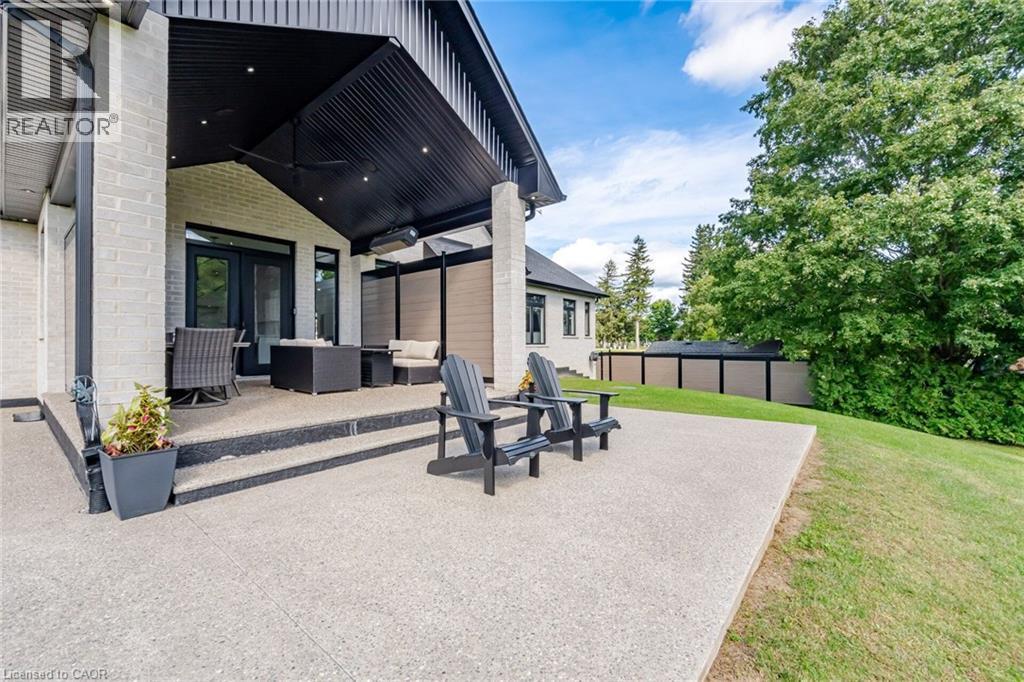 Expansive concrete patio with integrated steps, leading to a covered outdoor living area - 56 Augustus Street, Scotland, ON