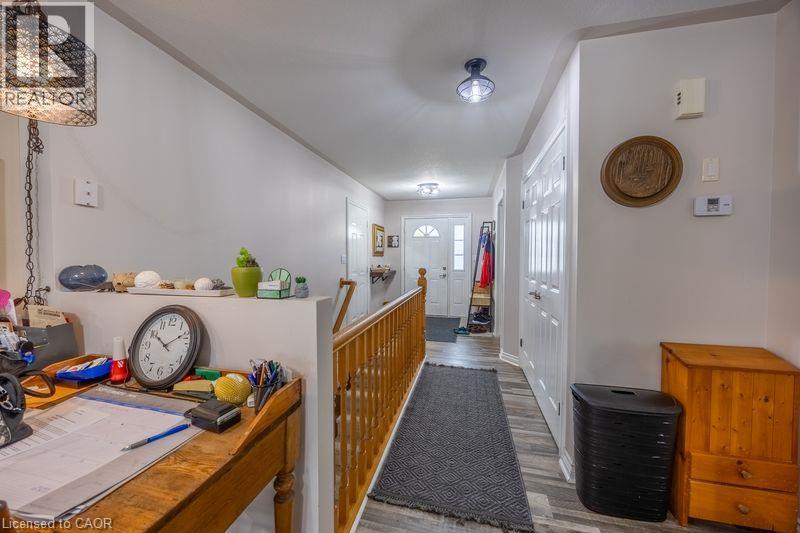 Hallway with wood-finish flooring, white walls, and recessed lighting - 123 Mill Street, Delhi, ON