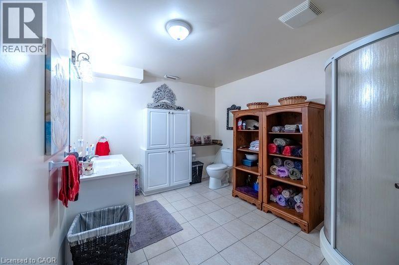 White vanity with an integrated sink, polished chrome faucet, and overhead wall sconce - 123 Mill Street, Delhi, ON