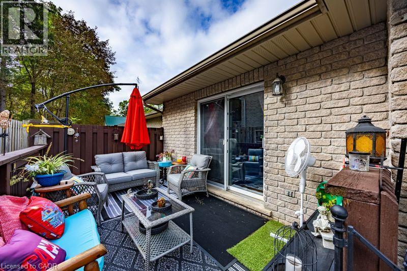 Enclosed patio with brick exterior, sliding glass door, overhead lighting fixture, and privacy fencing - 123 Mill Street, Delhi, ON
