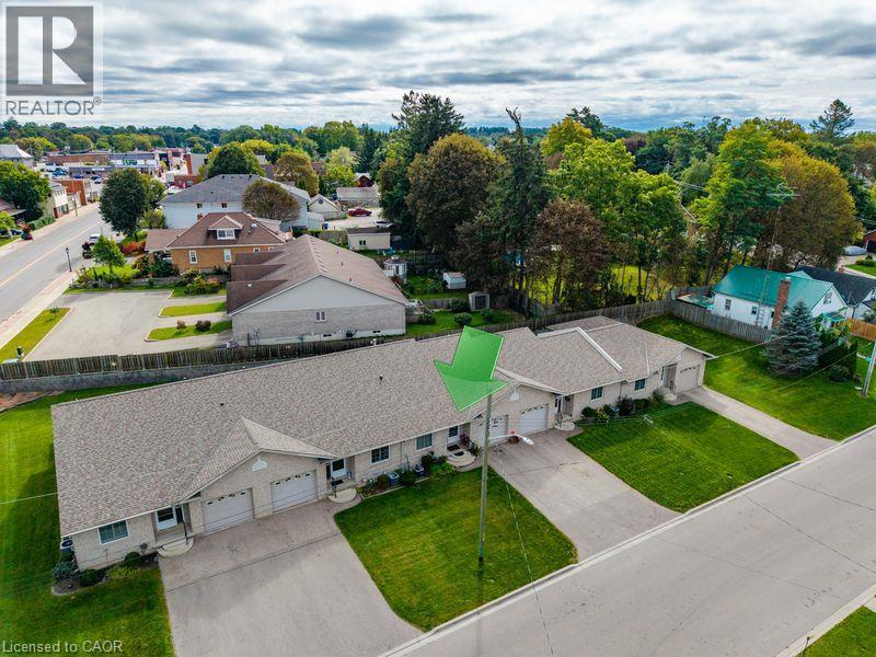 Duplex property featuring a neutral exterior, attached garages, and individual driveways - 123 Mill Street, Delhi, ON