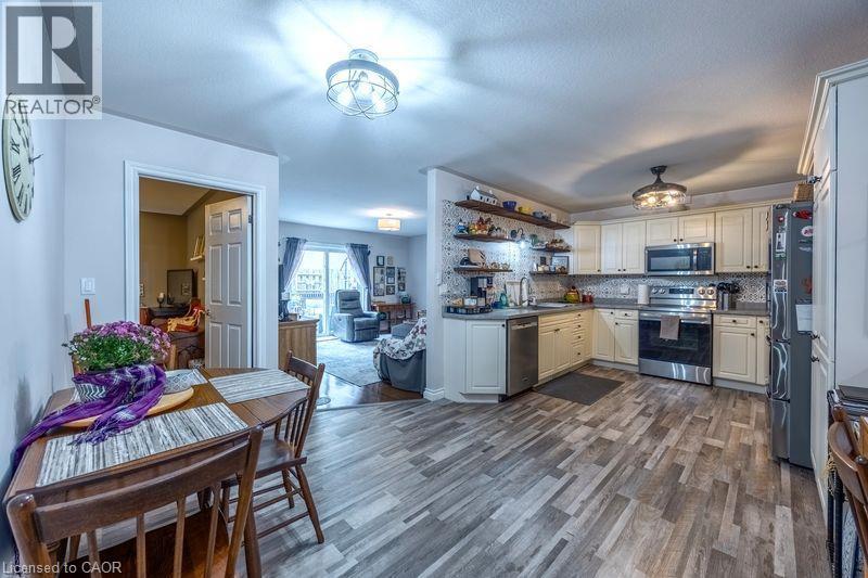 Kitchen featuring light-finish cabinetry, stainless steel appliances, open shelving, and wood-finish flooring - 123 Mill Street, Delhi, ON