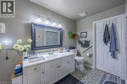White vanity with a single basin sink, framed mirror, and decorative tile flooring -