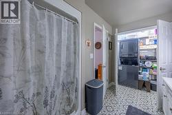 Built-in laundry closet with stacked washer and dryer, patterned floor tile, and white cabinetry with drawer pulls -