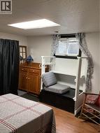 Room interior featuring wood-finish flooring, a recessed ceiling light, and a built-in window well with a rectangular awning-style window -