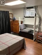 Room featuring wood-finish flooring, recessed lighting, and a window with a window well cover -