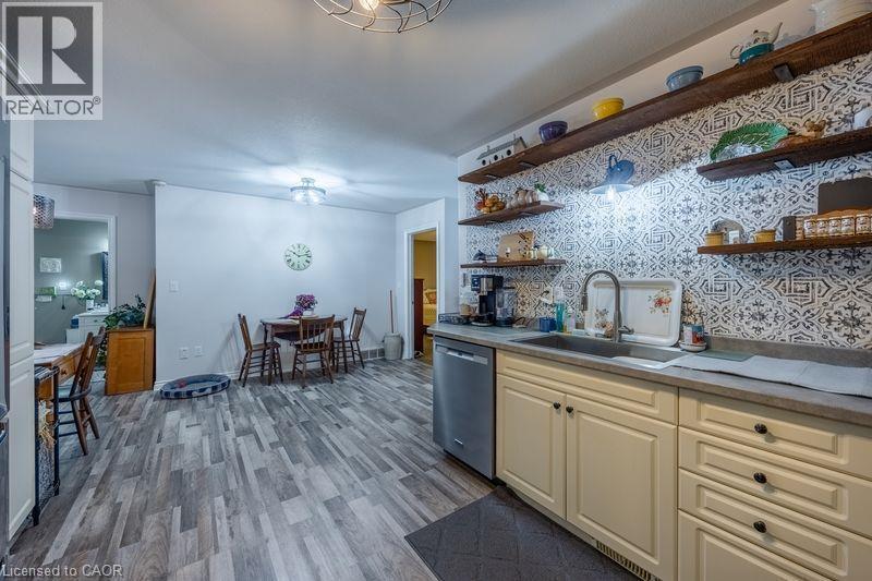 Wood-finish flooring throughout, with a patterned backsplash and open wood shelving - 123 Mill Street, Delhi, ON