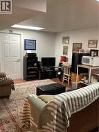 Room featuring neutral-toned walls, wood-finish flooring, and a recessed ceiling lighting fixture with a solid-core interior door -