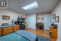 Wood-finish flooring, white paneled doors, ceiling-mounted fluorescent lighting fixture, and a built-in closet with bifold doors -