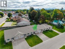 Duplex property featuring a neutral exterior, attached garages, and individual driveways -
