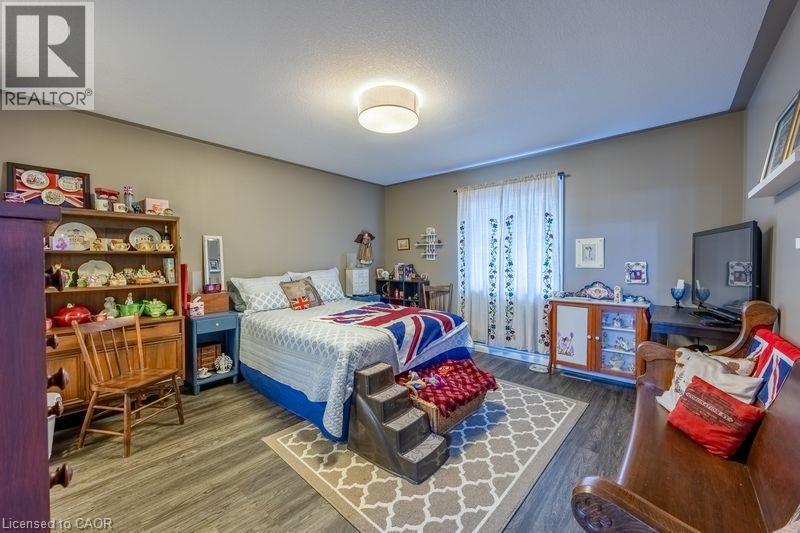 Room featuring wood-finish flooring, neutral wall tones, and a ceiling-mounted light fixture - 123 Mill Street, Delhi, ON