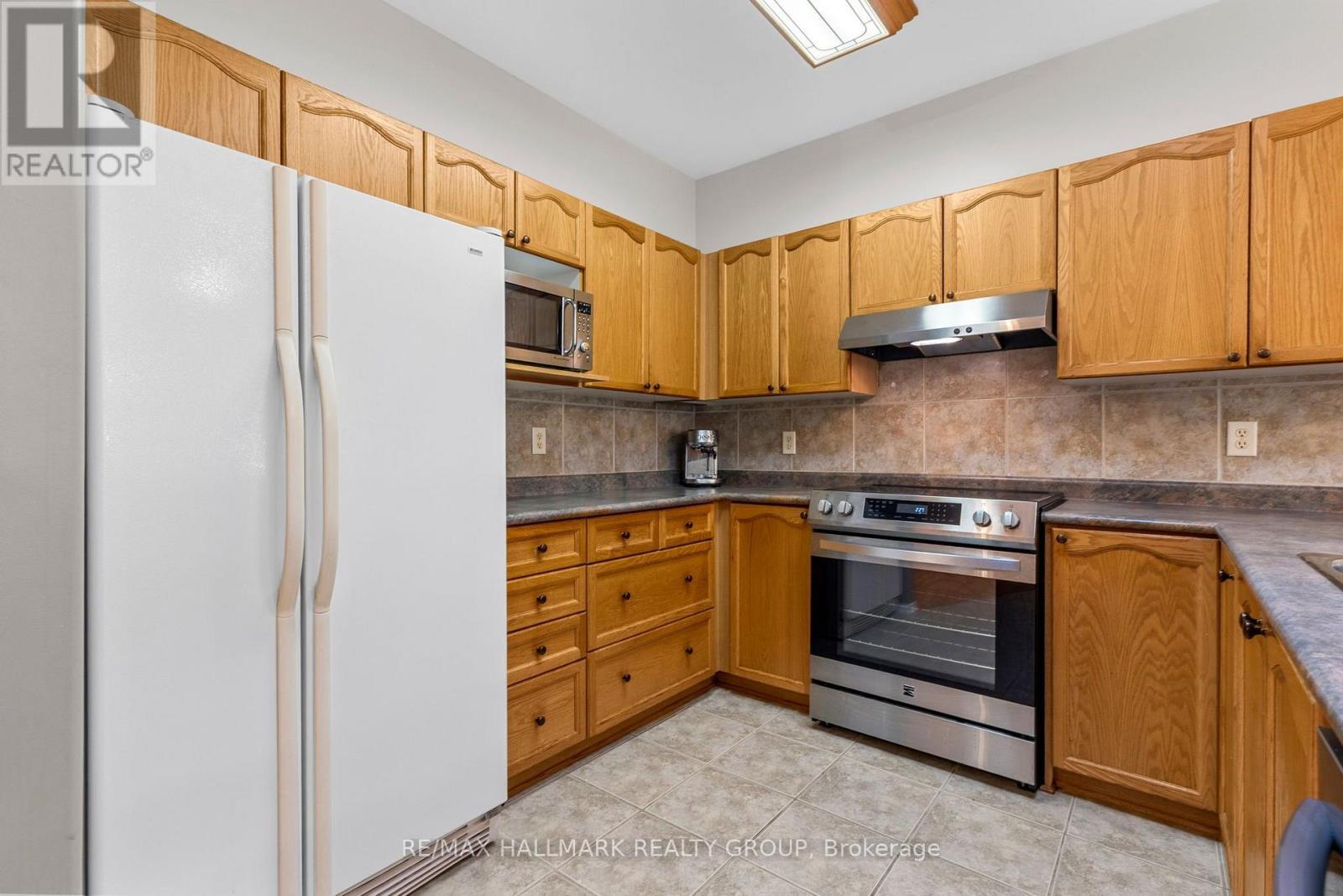 Kitchen with wood cabinetry - 5 Rayburn Street, Ottawa, ON