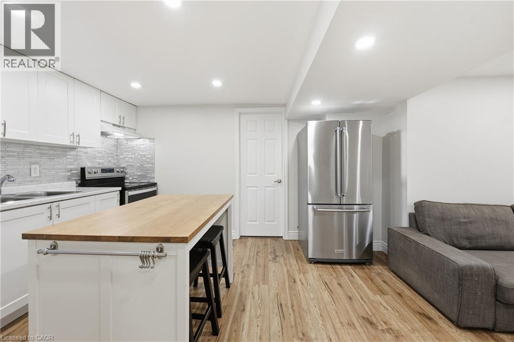 Full kitchen with white cabinetry, stainless steel appliances, wood-finish flooring, and recessed lighting - 312 Upper Paradise Road, Hamilton, ON