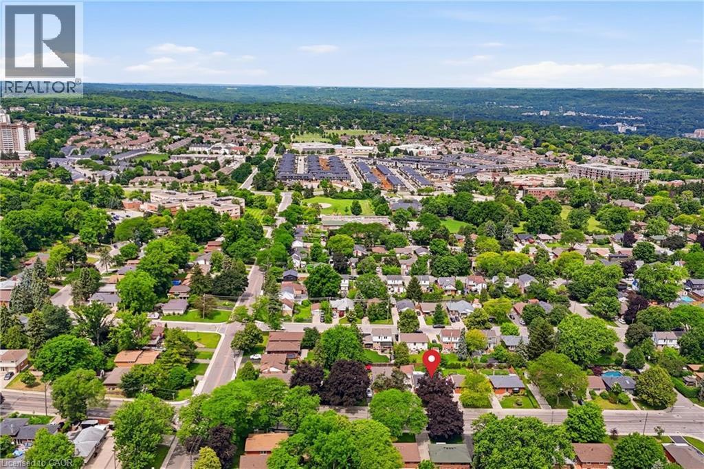 Suburban neighborhood with mature trees, established residential properties, and distant commercial structures - 312 Upper Paradise Road, Hamilton, ON