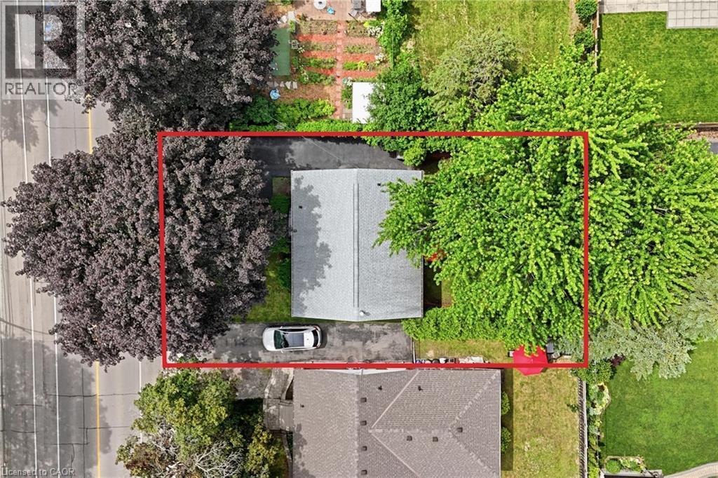 Mature trees providing shade, paved driveway, and gabled roofline - 312 Upper Paradise Road, Hamilton, ON