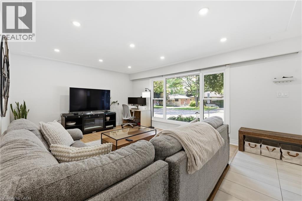 Recessed ceiling lighting, large window with ample natural light, wood-finish flooring, and light-toned wall finishes - 312 Upper Paradise Road, Hamilton, ON