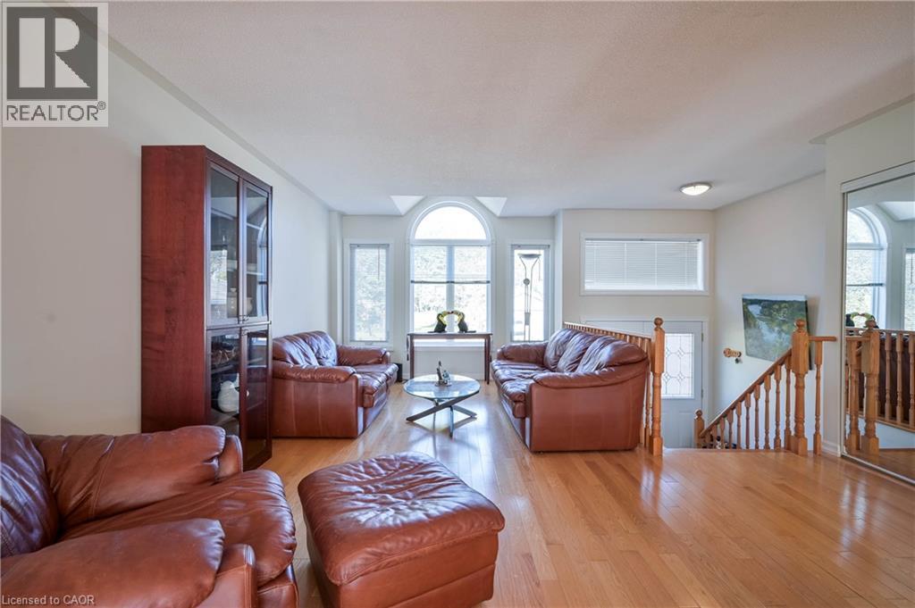 Hardwood flooring, arched transom window, built-in display cabinet, natural light, and wood banister - 12 Langevin Drive, Wasaga Beach, ON