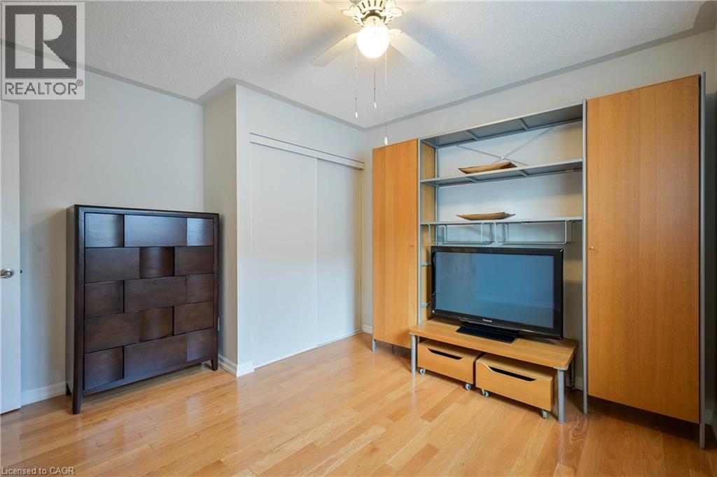 Light wood-finish flooring, built-in storage system with shelving and cabinetry, ceiling fan with integrated lighting, and sliding closet doors - 12 Langevin Drive, Wasaga Beach, ON
