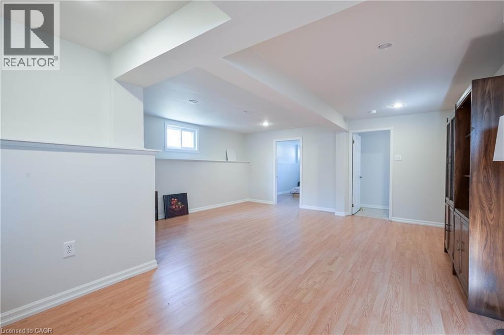 Expansive interior space featuring wood-finish flooring, recessed lighting, and a window for natural light - 12 Langevin Drive, Wasaga Beach, ON