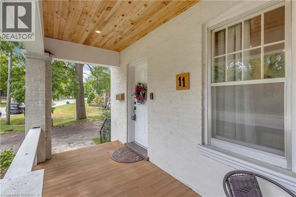 Covered front porch featuring a wood-finish ceiling with recessed lighting, exposed brick pillars, and wood-finish flooring - 11 Tutela Heights Road, Brantford, ON