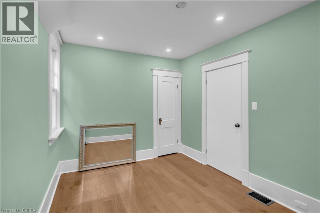 Recessed lighting, wood-finish flooring, white trim, and a window for natural light - 11 Tutela Heights Road, Brantford, ON