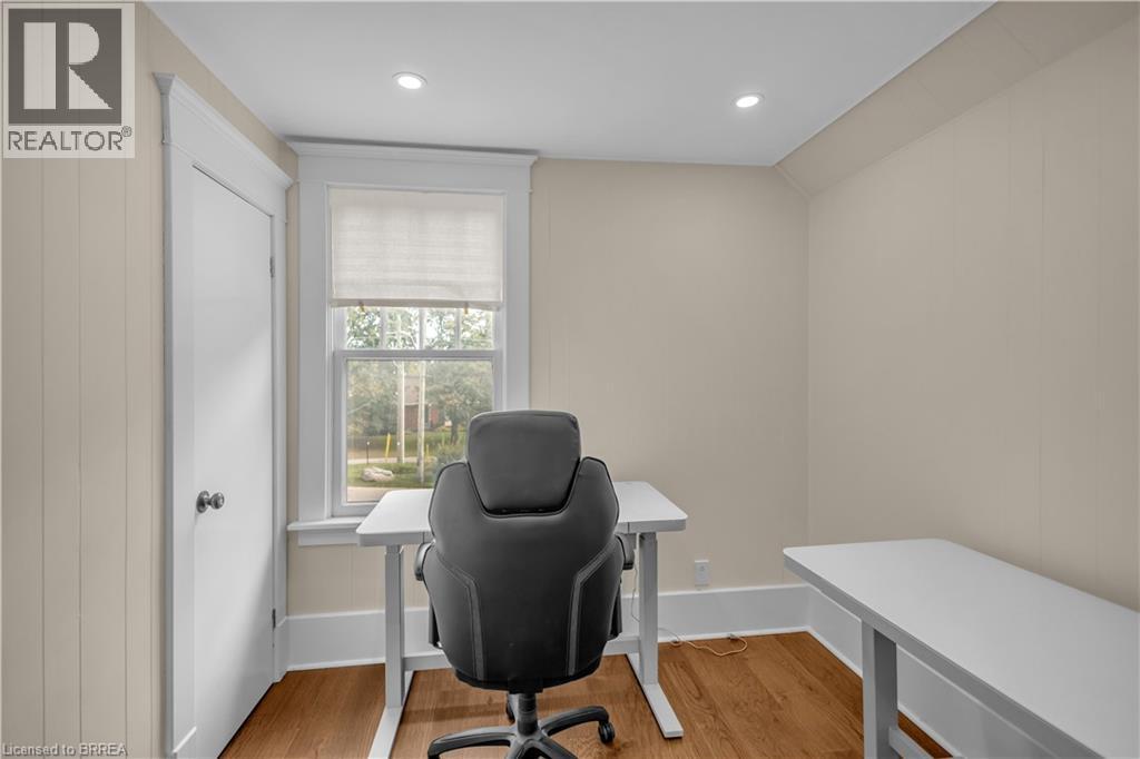 Hardwood flooring, recessed ceiling lights, paneled walls, and a window with trim - 11 Tutela Heights Road, Brantford, ON