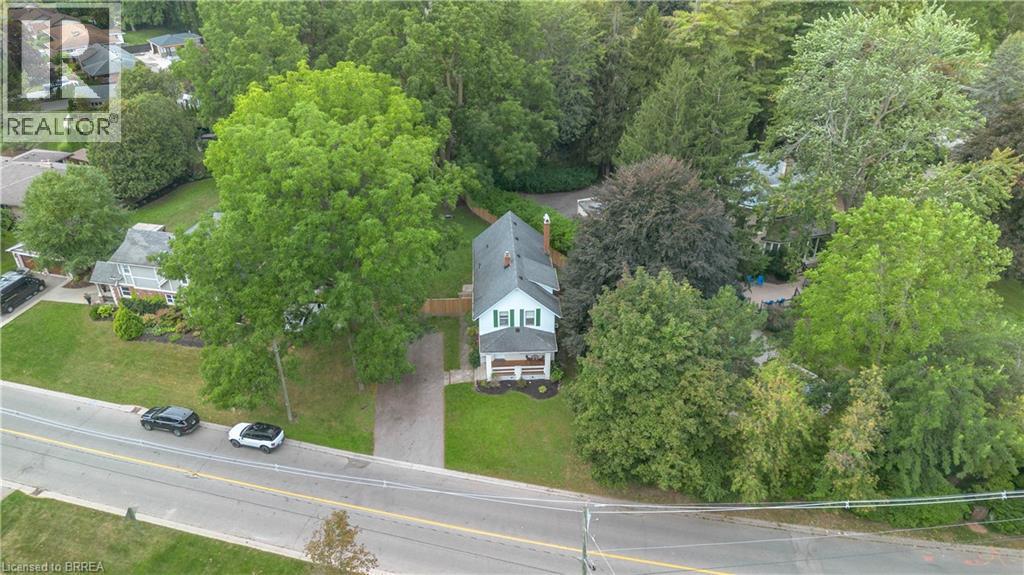White exterior with dark shutters, front porch with columns, and a gabled roof - 11 Tutela Heights Road, Brantford, ON