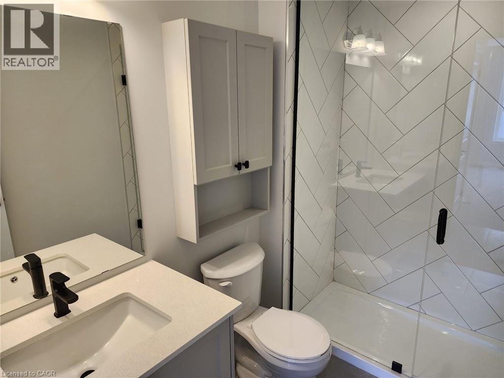 Bathroom featuring a vanity with an integrated sink, matte black faucet, and a wall-mounted medicine cabinet - 155 Equestrian Way Unit# 152, Cambridge, ON