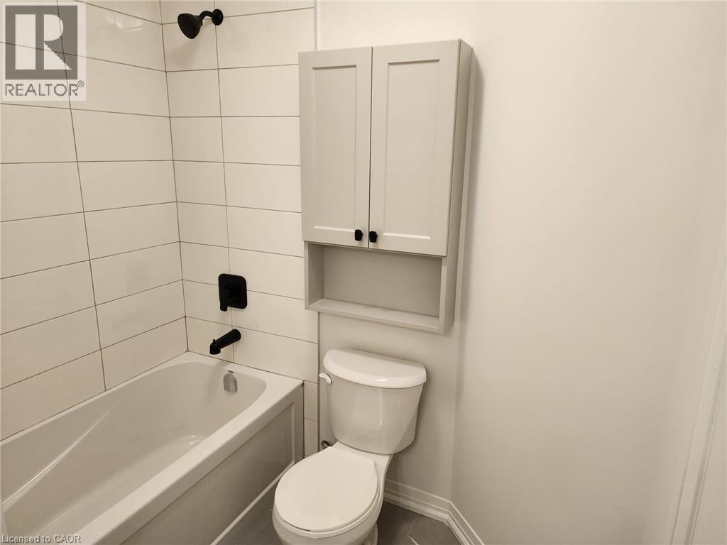 Bathtub with white subway tile surround and matte black fixtures - 155 Equestrian Way Unit# 152, Cambridge, ON
