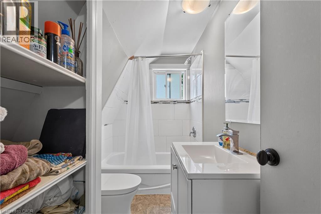 Bathroom featuring a white bathtub, tiled shower surround, and a window with natural light - 42841 Highway 3, Wainfleet, ON
