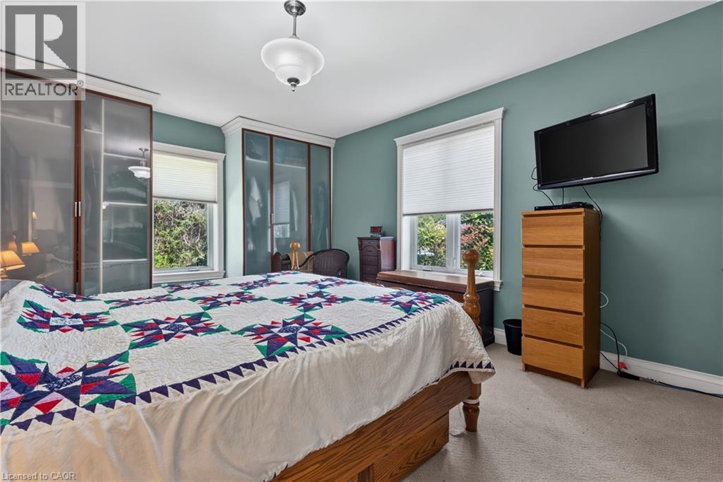 Bedroom featuring two windows with white blinds, light green walls, and carpet flooring - 42841 Highway 3, Wainfleet, ON