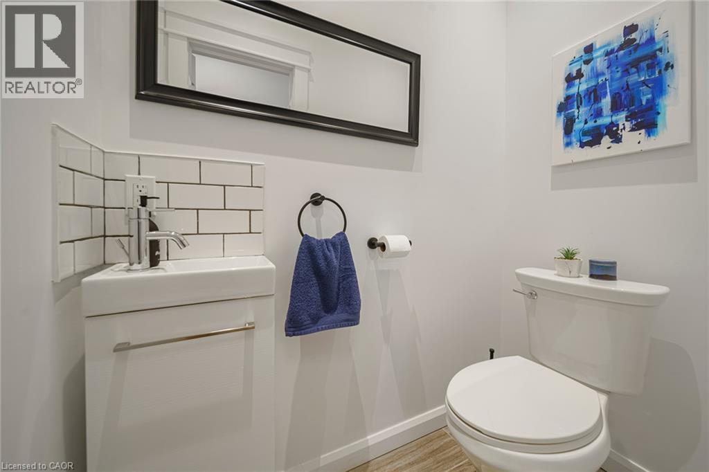 Corner vanity with subway tile backsplash, chrome faucet, and rectangular mirror - 28 Cambridge Street, Cambridge, ON