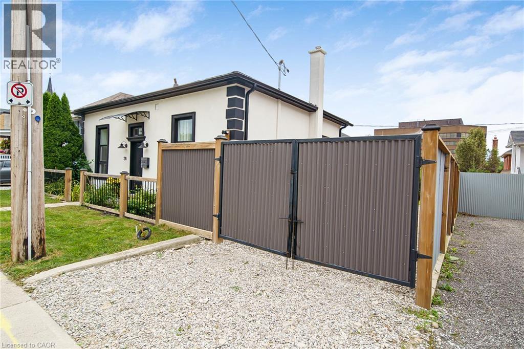White stucco exterior with black trim accents and a black entry door - 28 Cambridge Street, Cambridge, ON