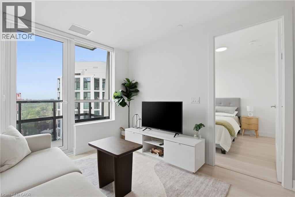 Expansive window wall with balcony access, light wood-finish flooring, recessed lighting, and a neutral color palette - 60 Central Park Roadway Unit# 2010, Etobicoke, ON