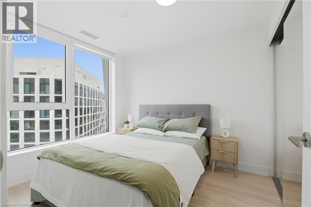 Expansive window with roller shade, light wood-finish flooring, recessed ceiling lighting, and a sliding barn door - 60 Central Park Roadway Unit# 2010, Etobicoke, ON