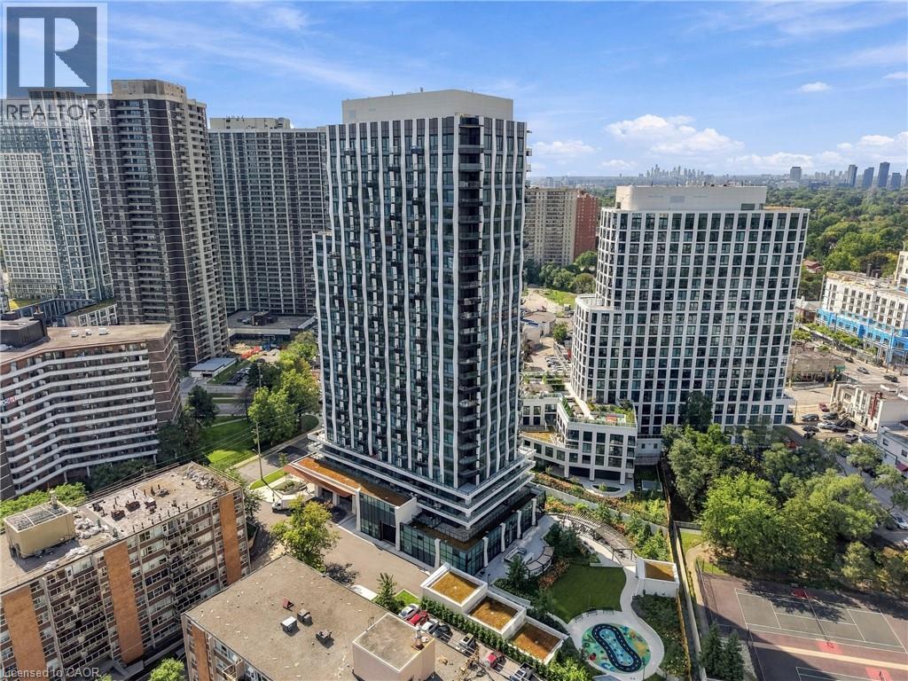 Modern high-rise residential building featuring a distinct facade, multiple balconies, a ground-level amenity area with green space, and a hardscaped terrace - 60 Central Park Roadway Unit# 2010, Etobicoke, ON