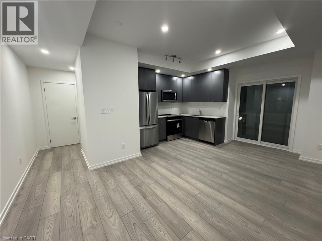 Modern kitchen with dark cabinetry, stainless steel appliances, and light-toned countertops - 17 Lytham Green Circle Unit# 27, Newmarket, ON