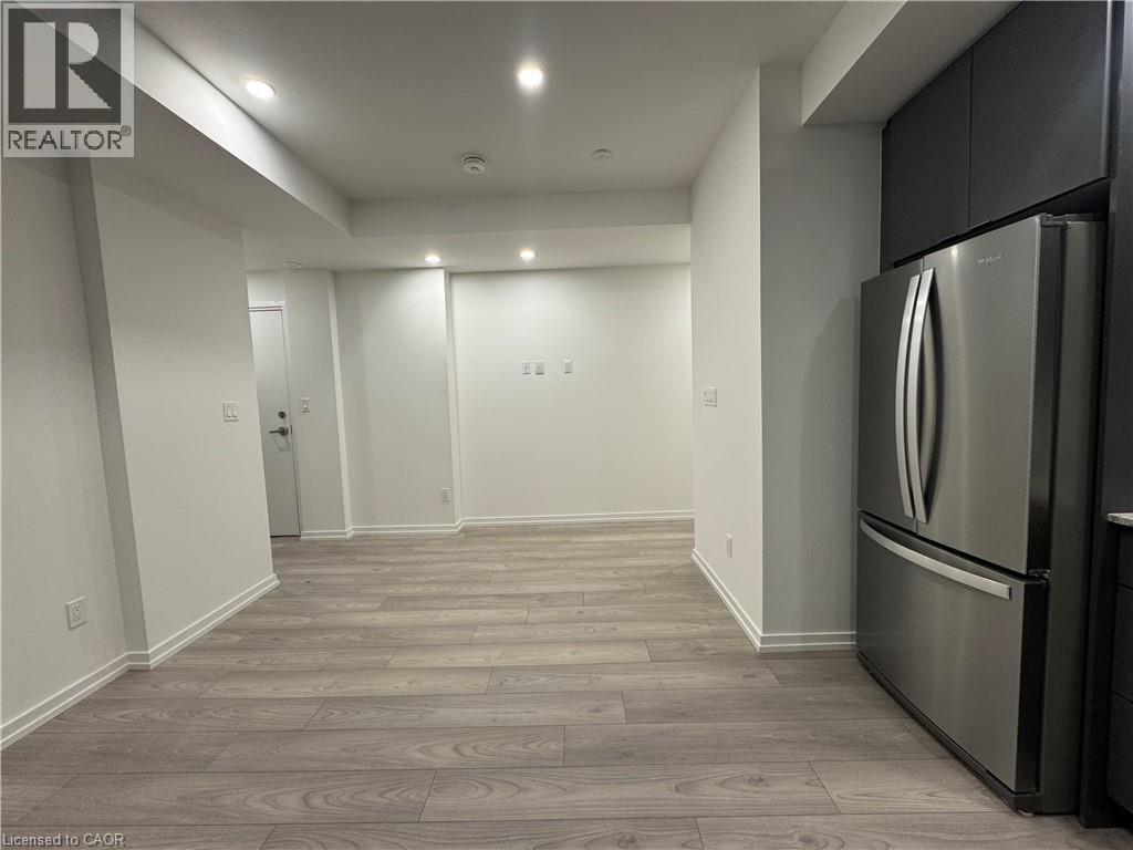 Integrated kitchen with stainless steel refrigerator and dark cabinetry - 17 Lytham Green Circle Unit# 27, Newmarket, ON