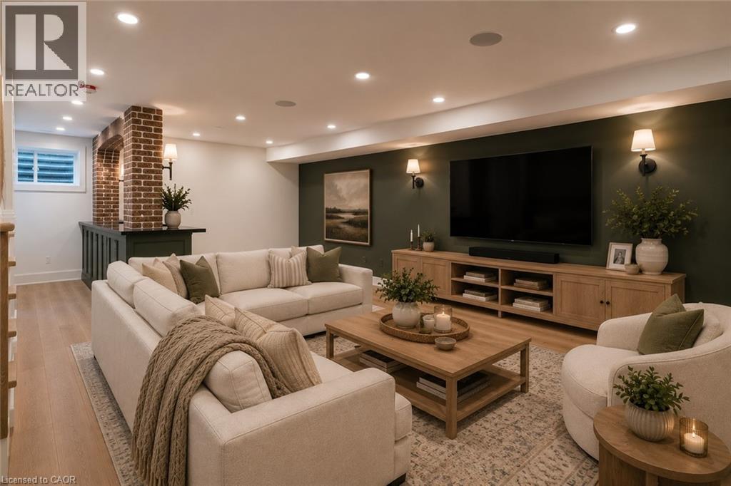 Finished lower level featuring recessed lighting, light wood-finish flooring, a built-in wet bar with a brick archway, a media wall with sconce lighting, and a window with security bars - 130 Edgecliffe Place, Halton, ON