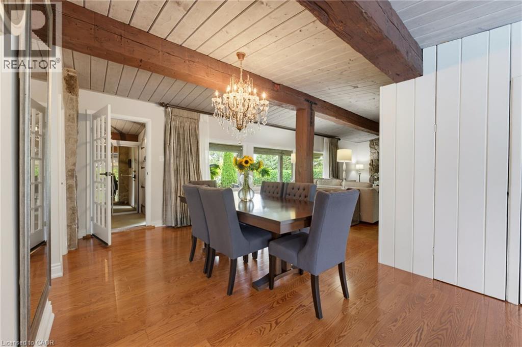 Hardwood flooring with exposed ceiling beams and a chandelier - 1316 Nevarc Drive, Burlington, ON