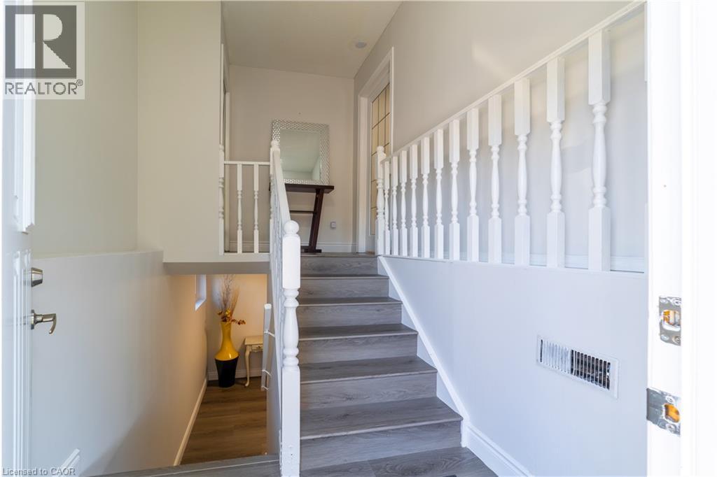Staircase with wood-finish treads and white balusters - 137 Nickolas Crescent, Cambridge, ON