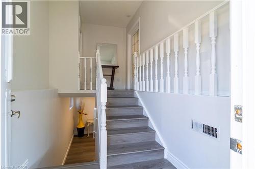Staircase with wood-finish treads and white balusters - 137 Nickolas Crescent, Cambridge, ON 