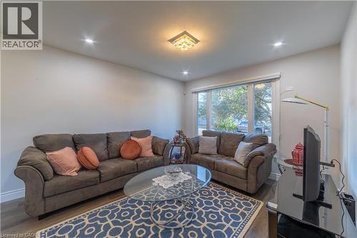 Recessed ceiling lighting, a central decorative ceiling light fixture, wood-finish flooring, and a large window - 137 Nickolas Crescent, Cambridge, ON 