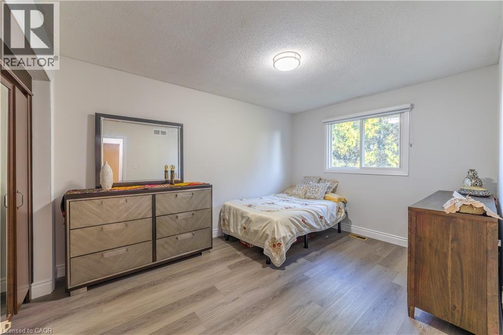 Recessed lighting fixture, light gray wall color, window with roller shade, wood-finish flooring, and a mirrored closet door - 137 Nickolas Crescent, Cambridge, ON
