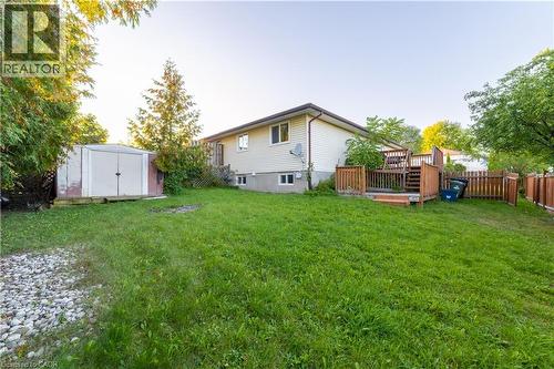 Expansive grass lawn with a multi-level wood deck, wood privacy fencing, and a metal storage shed - 137 Nickolas Crescent, Cambridge, ON 