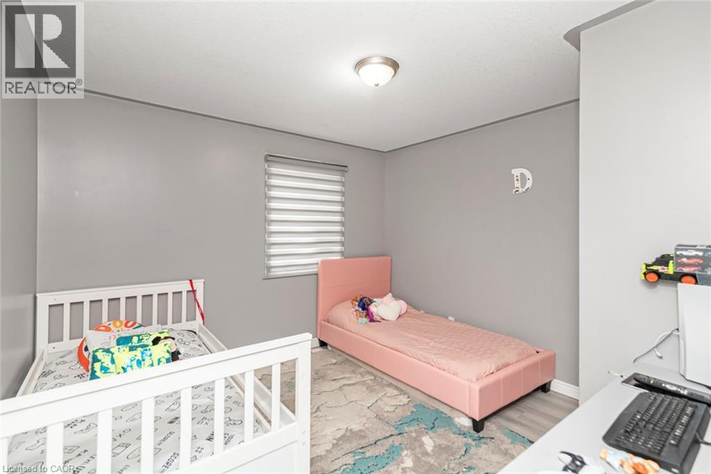 Neutral wall paint, window with horizontal blinds, overhead flush mount light fixture, and wood-finish flooring - 42 Saturn Road, Port Colborne, ON